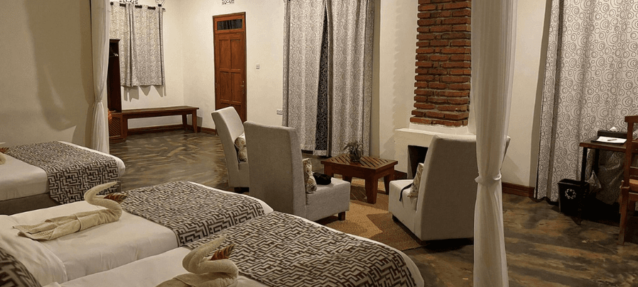 Comfortable twin room at Marera Valley Lodge with cozy seating area, fireplace, and warm décor creating a relaxing atmosphere